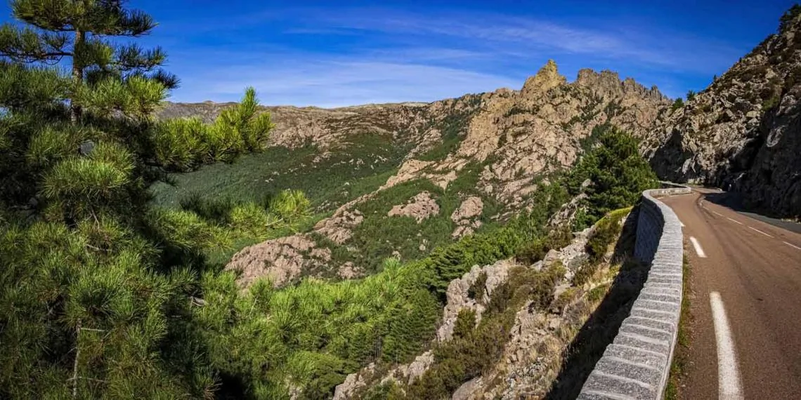 Aiguilles de Bavella in Corsica with dramatic granite peaks above a winding mountain road