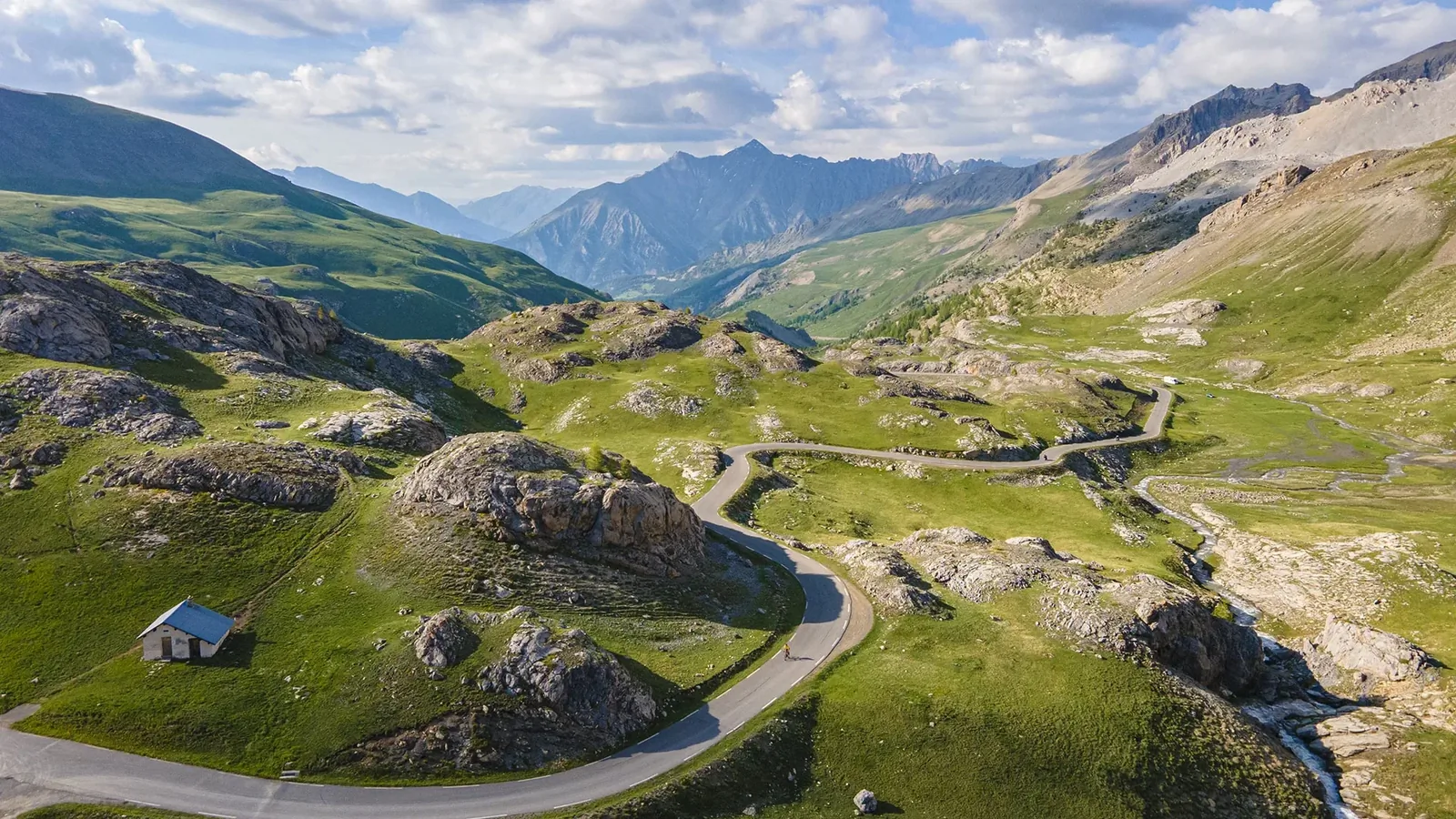 Col de la Bonette in the Mercantour with stone cairns and a winding road climbing a barren summit
