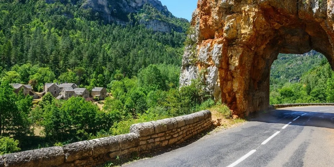 Scenic road winding along the Tarn river canyon between tall limestone cliffs