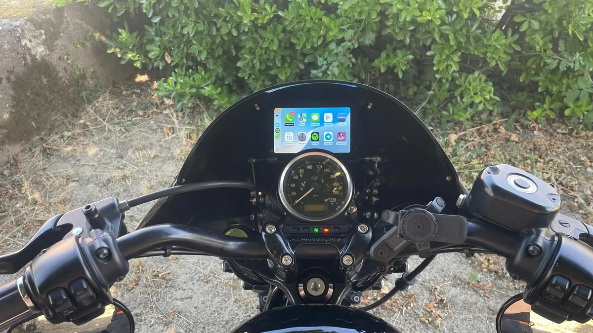 Carpuride 502H affichant l'écran d'accueil Apple CarPlay avec Spotify sur un tableau de bord Harley-Davidson