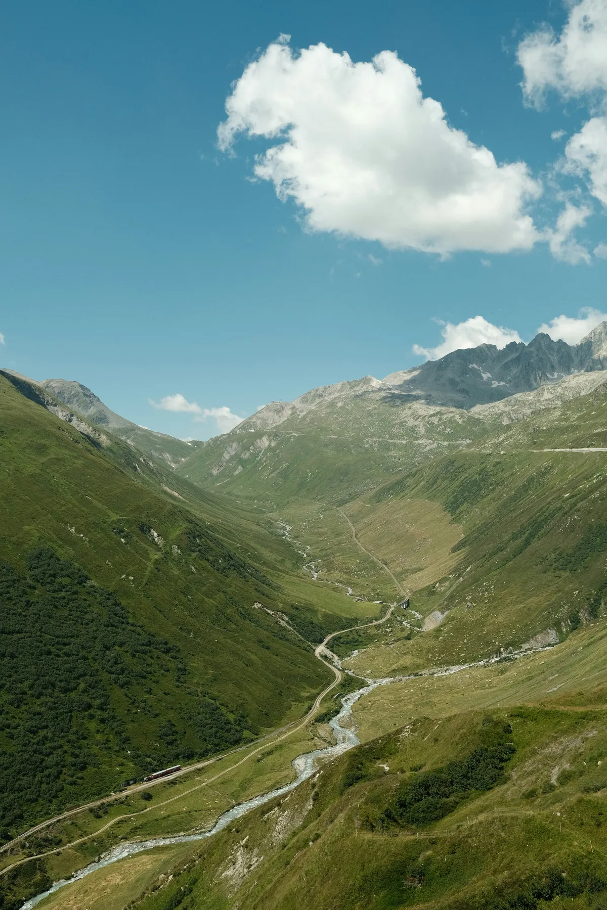 Furka Pass valley in Switzerland with road and river
