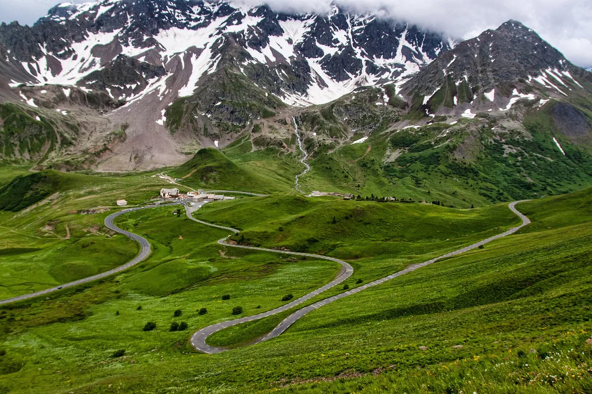 Winding road of Col du Galibier with snow-capped peaks