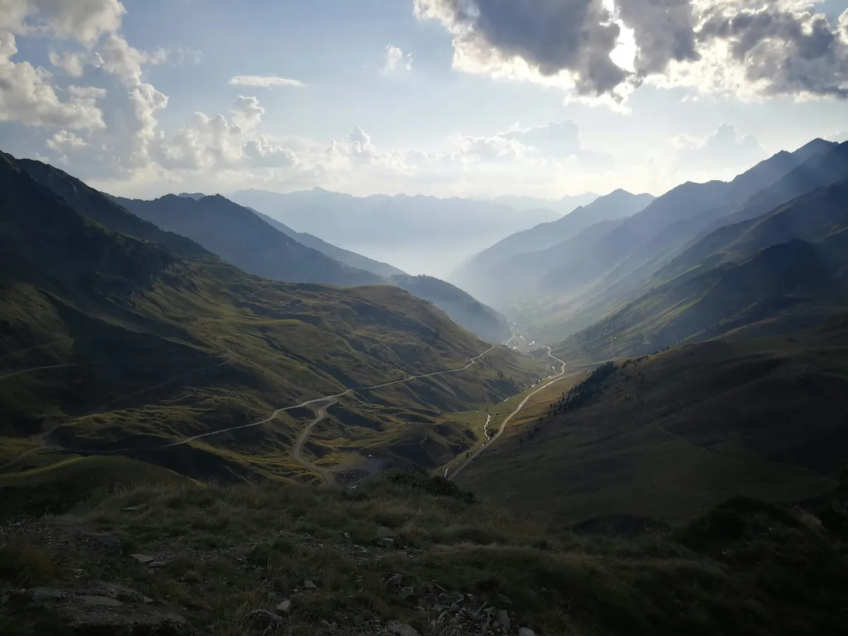 Panorama from Col du Tourmalet with winding road in the valley